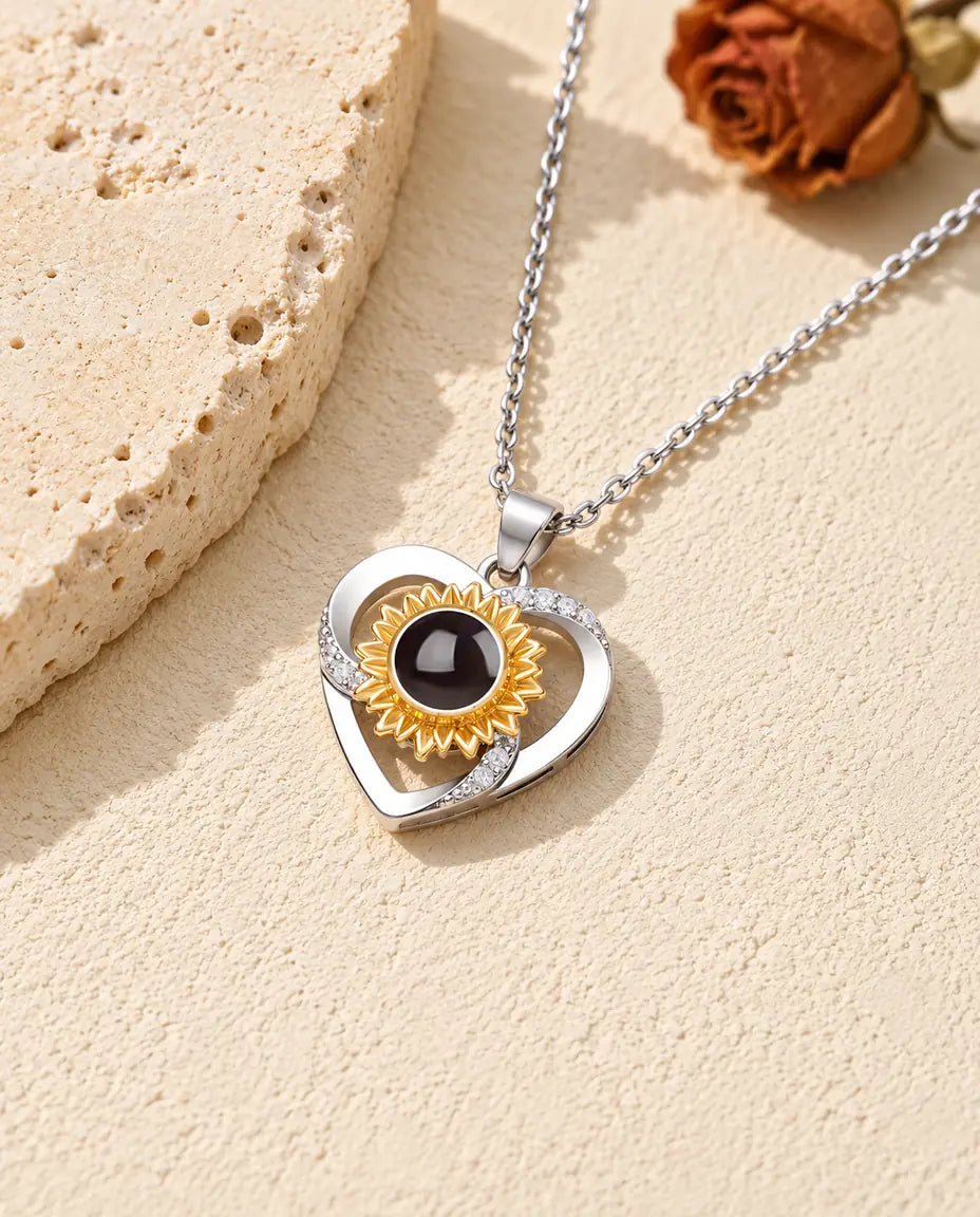 Personalized sunflower heart photo projection necklace with a gold tone sunflower on travertine