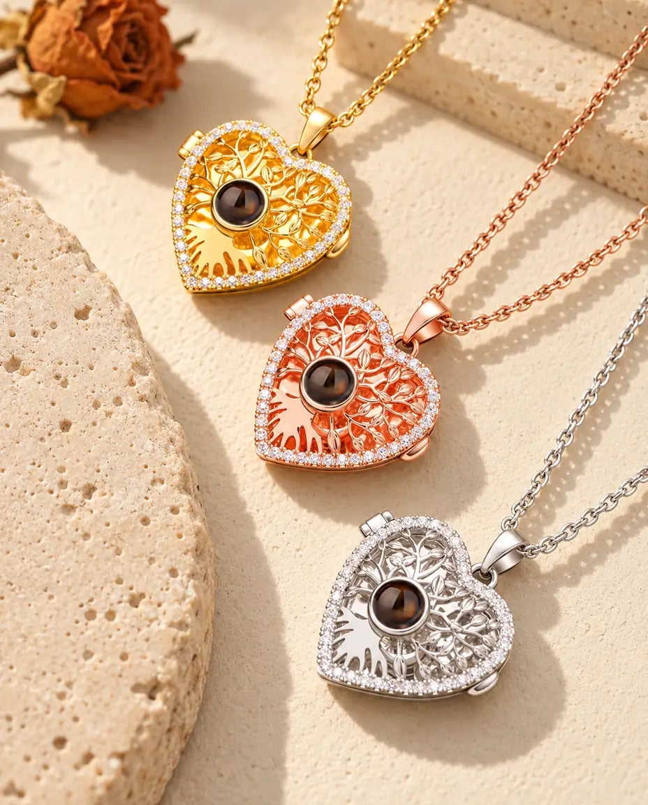 Gold tone, rose gold tone and silver tone tree of life heart lockets arranged beside a travertine slab