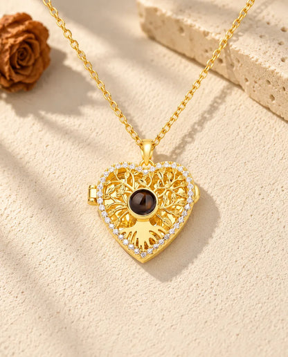 Front view of the gold tone tree of life heart locket with the projection stone at the center