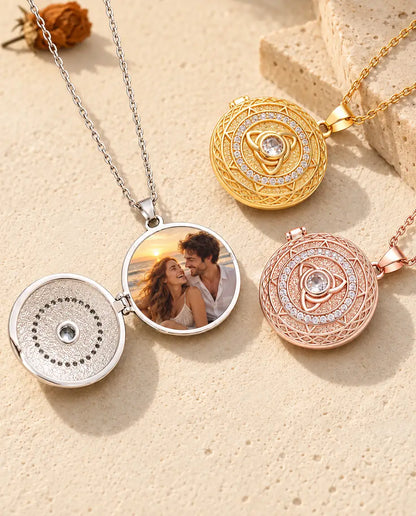 Silver tone trinity knot locket opened to show a couple's beach photo inside, next to closed gold tone and rose gold tone lockets