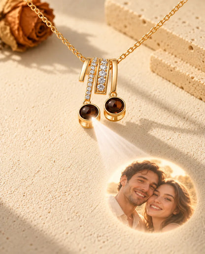 Light shining through one brown stone of the gold tone slide necklace projects a photo of a smiling couple