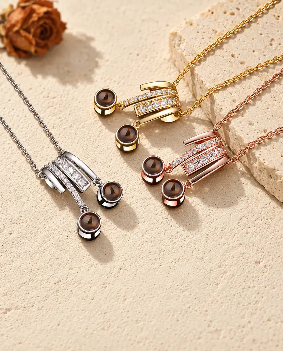 Silver tone, gold tone and rose gold tone slide necklaces with two projection stones each, clustered by a travertine slab