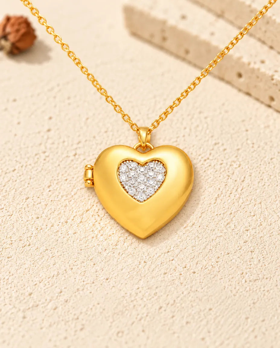 Front view of the gold tone two-tone pave heart photo locket showing the lid design and side hinge