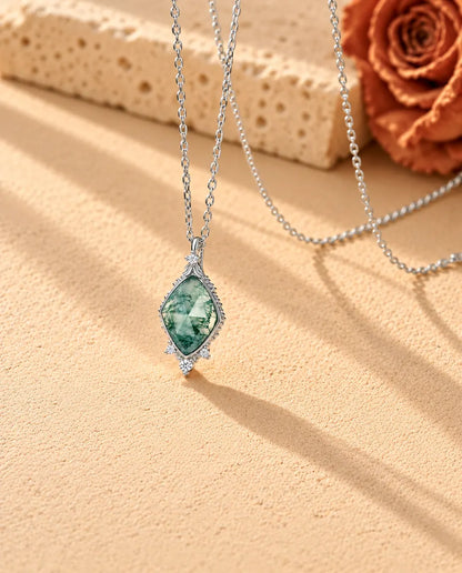 Rose Cut Moss Agate Lozenge Necklace in 925 Sterling Silver - seen at an angle on a cream textured surface