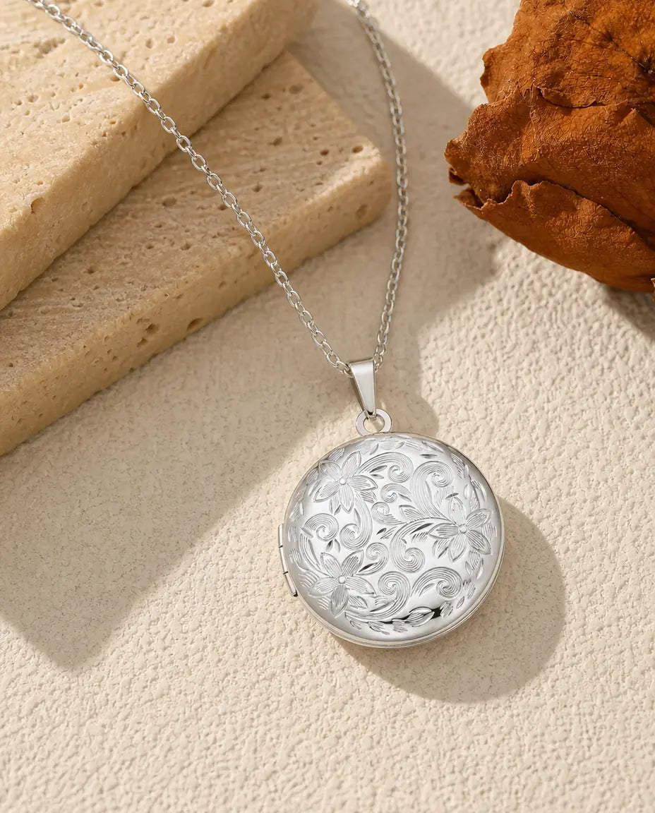 Round photo locket necklace in polished silver with all-over floral scroll engraving