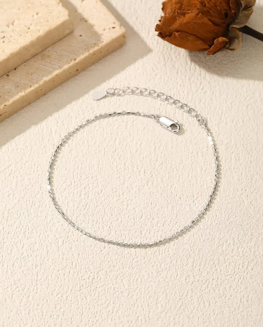 Sparkle Chain Bracelet in 925 Sterling Silver - laid flat on a cream textured surface with the clasp and extender